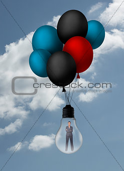 Businesswoman inside light bulb held by balloons