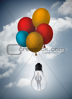 Businessman inside light bulb held by balloons