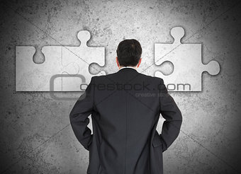 Businessman figuring out puzzle