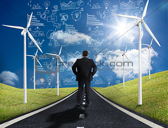 Businessman standing in middle of road looking at graphs on the horizon