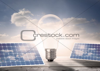 Light bulb and solar panels on floorboards in the sky
