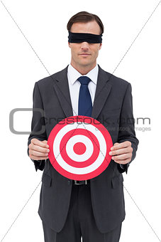 Blindfolded businessman holding a red target