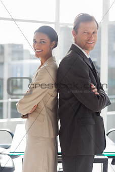 Smiling business people standing back to back