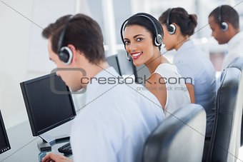 Attractive call centre employee looking over shoulder