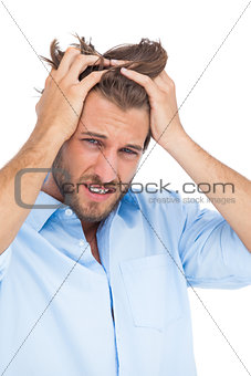 Tanned stressed man holding his hair