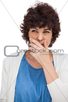 Brunette woman with hand on her mouth
