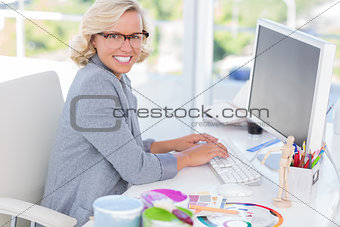 Cheerful interior designer working on her computer
