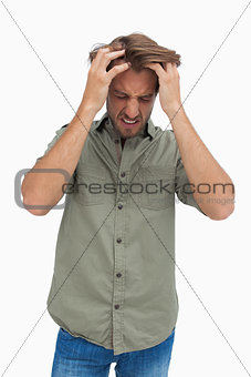 Frustrated man pulling his hair and looking down