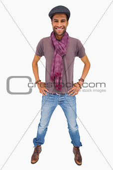Happy man wearing peaked cap and scarf looking at camera
