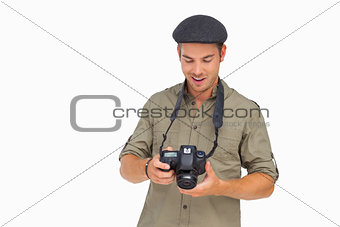 Happy man in peaked cap holding camera