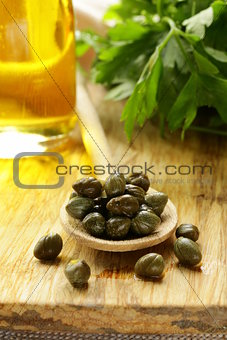 Pickled capers in a wooden spoon