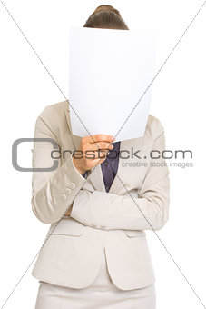 Business woman holding document in front of face