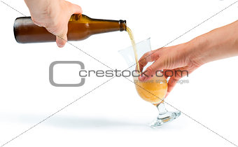Hand holding bottle of beer and beer mug