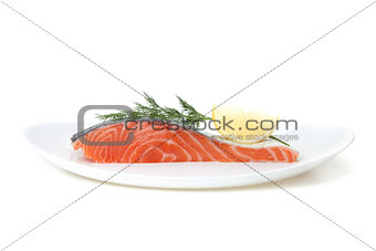 Piece of salmon with lemon and dill on plate