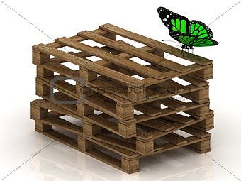 Green butterfly is sitting on a stack of wooden pallets