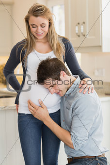 Man listening to stomach of pregnant woman