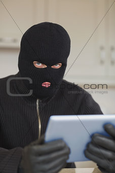 Suspicious burgler holding tablet pc