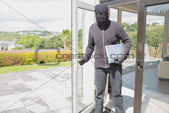 Burglar holding laptop