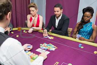 Man and two women playing poker