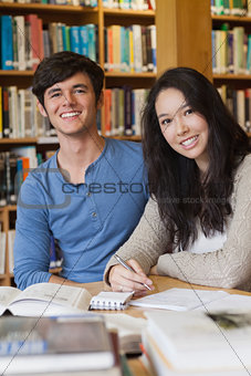 Two happy students in a library