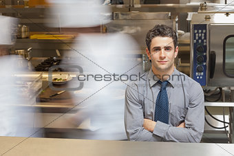 Waiter standing in busy kitchen