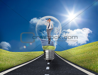 Businessman in light bulb with wind turbines and solar panels