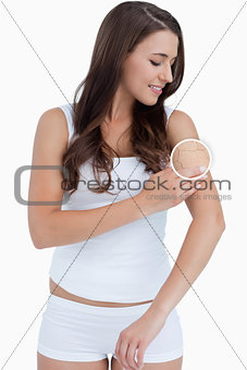 Standing woman rubbing her skin with close up of her wrinkles