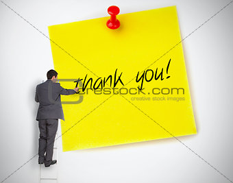 Businessman writing thank you on a giant post it