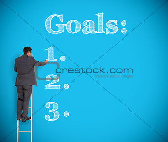 Businessman writing goals on a giant wall