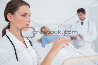 Serious doctor holding a syringe