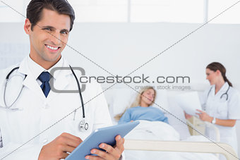 Handsome doctor using digital tablet