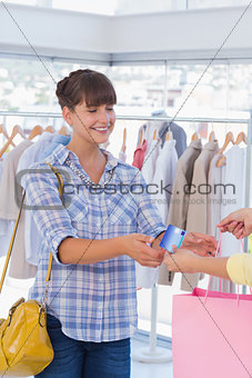 Cashier giving shopping bag and credit card