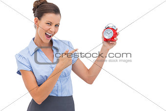 Businesswoman pointing at alarm clock