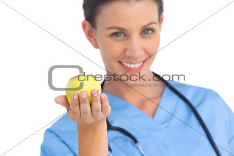 Happy surgeon holding an apple and smiling