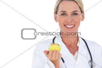 Happy doctor holding apple