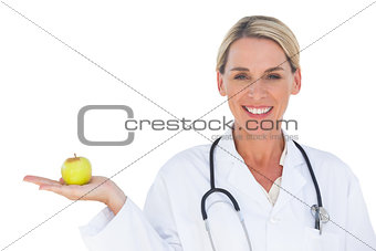 Smiling doctor holding apple