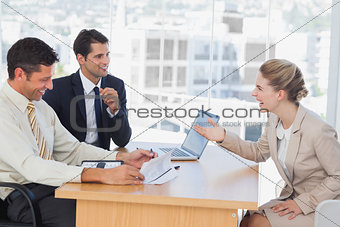 Business people laughing with interviewee