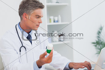 Serious doctor holding pills