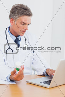 Attractive doctor holding a bottle of pills