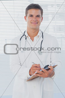 Handsome doctor holding a clipboard