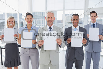 Buisness team holding up blank pages