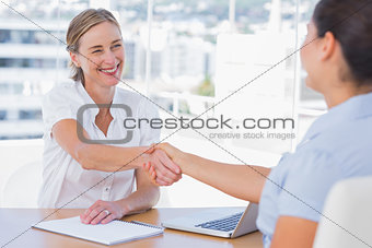 Smiling interviewer shaking hand of an applicant
