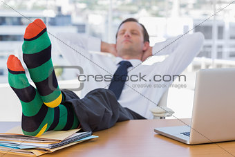 Businessman sleeping with feet on his desk