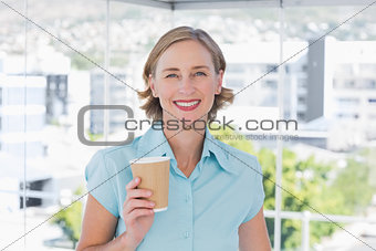 Businesswoman holding disposable coffee cup