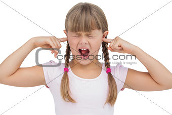 Funny little girl clogging her ears and wincing