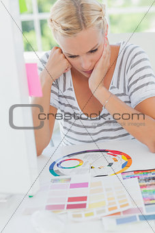 Thoughtful interior designer looking at a colour wheel