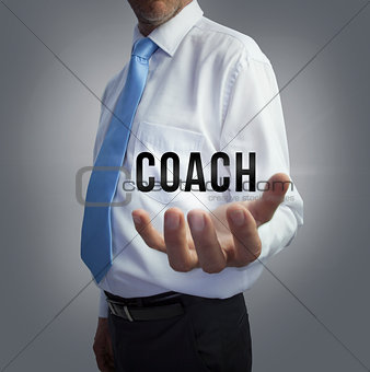 Businessman holding the word coach