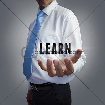 Businessman holding the word learn