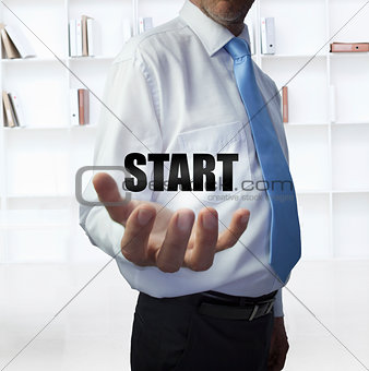 Elegant businessman holding the word start