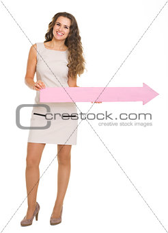 Full length portrait of smiling young woman pointing on copy spa